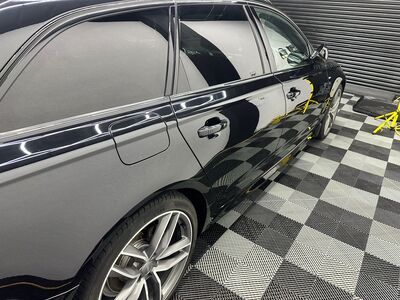 Side profile of a polished black Audi Avant estate with detailed alloy wheels