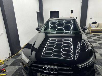 Deep paint reflection and polished finish on the front of a black Audi
