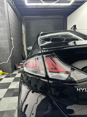 Close-up of a detailed hybrid vehicle taillight and polished paintwork