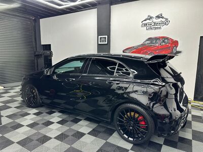 Clean side profile of a polished Mercedes-Benz A-Class hatchback with gloss black paint