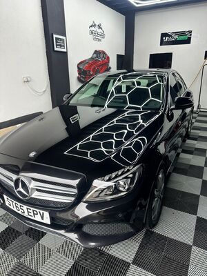 Polished front quarter of a black Mercedes-Benz sedan showing deep paint depth
