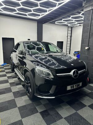 Bonnet reflection and front grille of a black Mercedes-Benz SUV after detailing