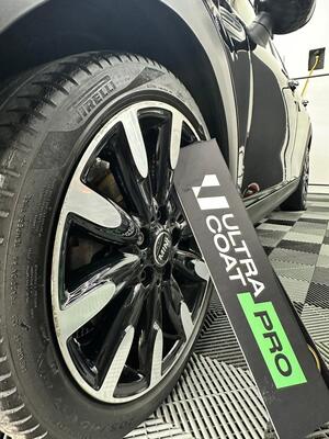 Detailed black and silver alloy wheel with tire dressing applied for protection