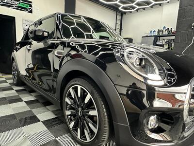 Black Mini Cooper showing glossy paint correction and reflection under detailing studio lights in Liverpool