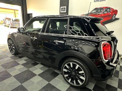 Side profile of a polished black Mini Cooper with deep gloss finish and clean wheels
