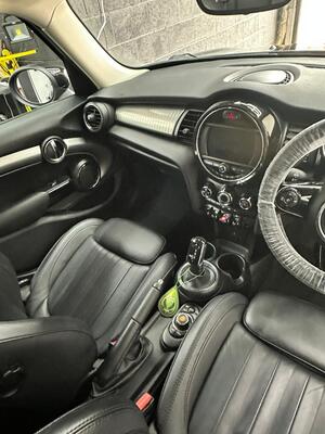Thoroughly cleaned black leather interior, dashboard, and steering wheel of a Mini Cooper