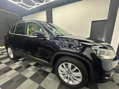 Side-front profile of a glossy black Volvo XC90 SUV with detailed wheels