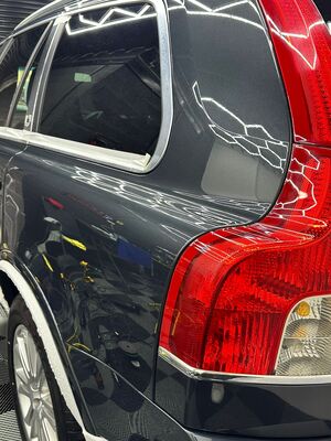 Grey Volvo XC90 rear quarter with masking tape applied for machine polishing trim protection
